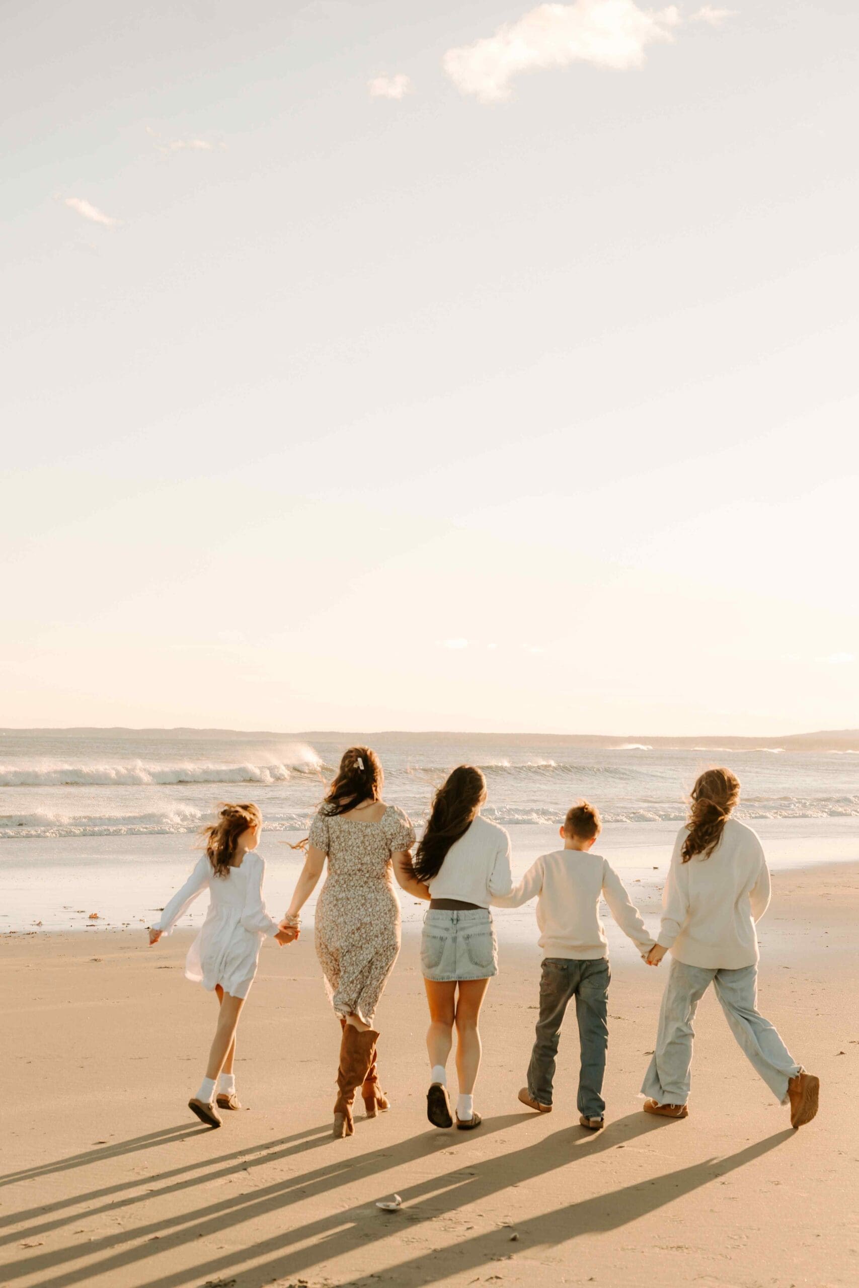 family running on the beach in maine